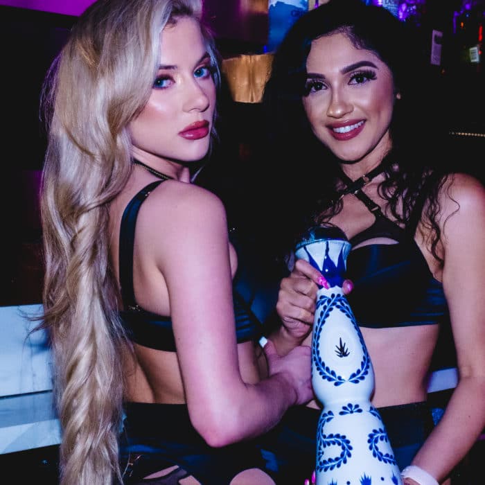 Two girls Holding Expensive Bottle liqour