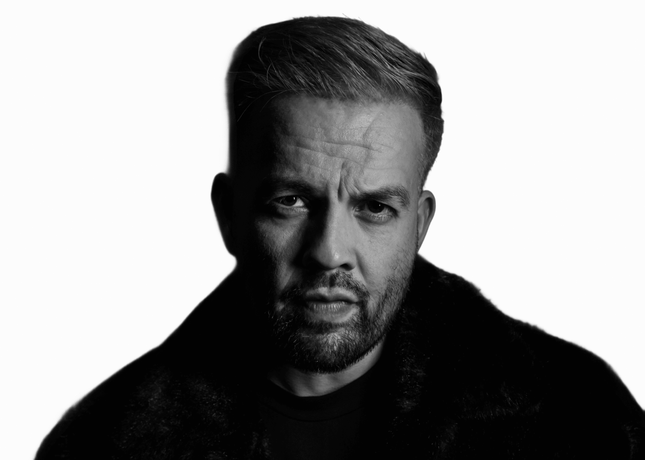 DJ SourMilk spinning on stage in a club, intensely focused as he drops a high-energy track.