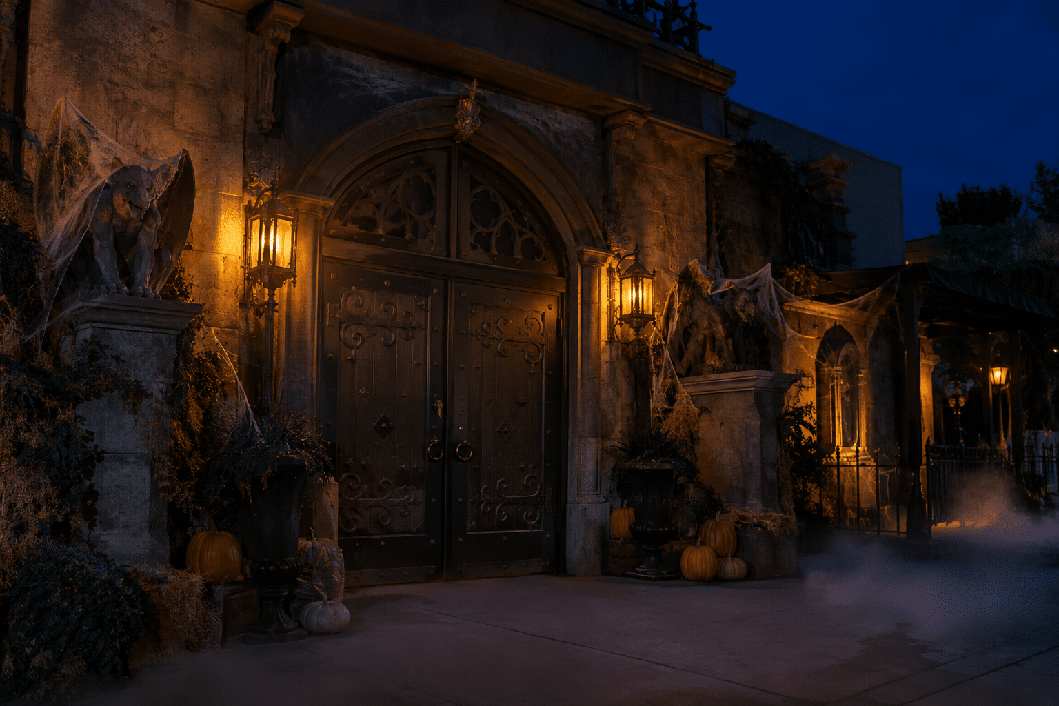 Closed haunted-house entrance with amber lanterns, cobwebs, pumpkins, and low fog.